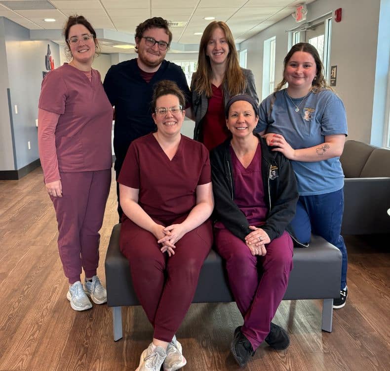 Dog sitting with woman talking to a vet